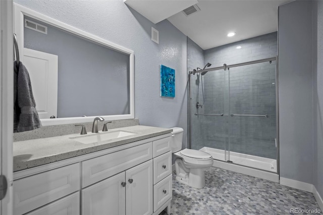 15604 Xenia Way, Brighton, CO 80602 - full bathroom featuring a shower stall, toilet, vanity, recessed lighting, and a textured wall