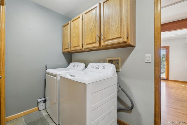 washroom with dark hardwood / wood-style flooring, washer and dryer, and cabinets