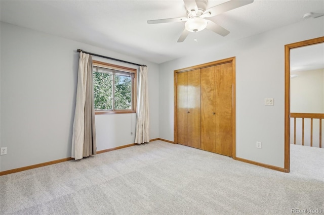 unfurnished bedroom featuring ceiling fan, a closet, and light carpet