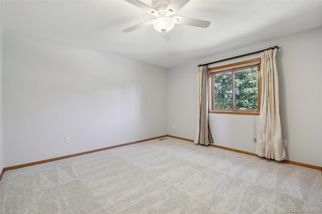 spare room with ceiling fan and light colored carpet