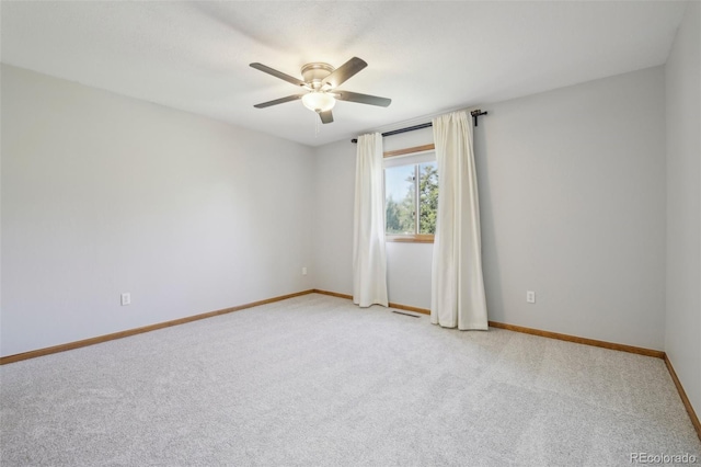 spare room with ceiling fan and light colored carpet