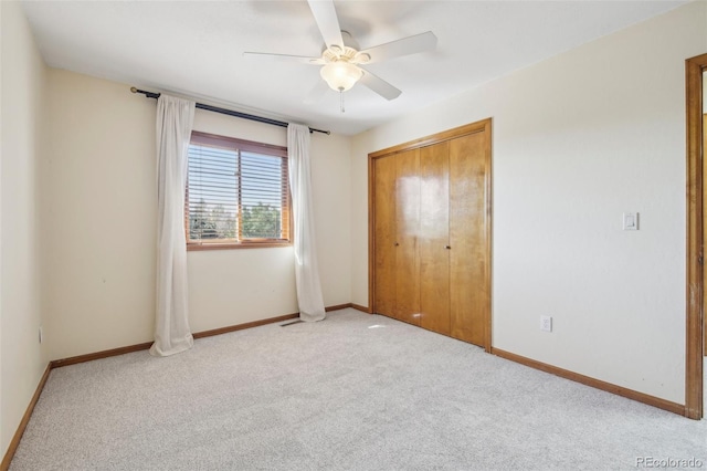 unfurnished bedroom featuring ceiling fan, a closet, and light carpet