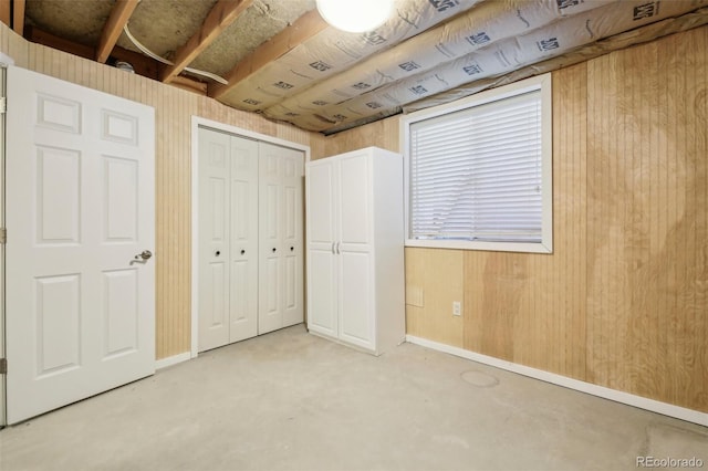 unfurnished bedroom featuring wooden walls and a closet