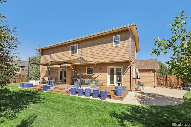 back of property featuring a deck, a lawn, and a patio area