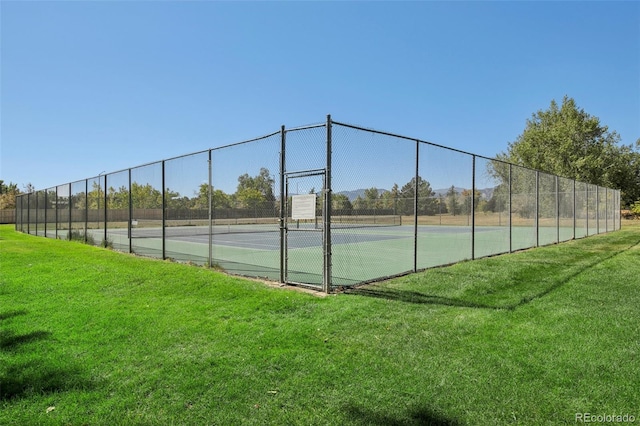 view of sport court with a yard