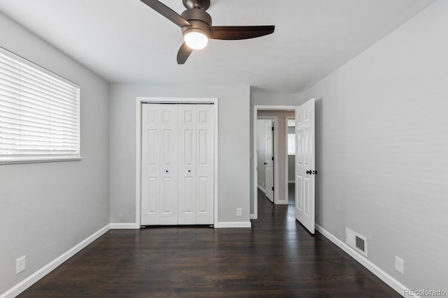 unfurnished bedroom featuring a closet, ceiling fan, and dark hardwood / wood-style flooring