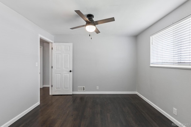 spare room with dark hardwood / wood-style floors and ceiling fan