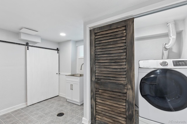 clothes washing area featuring washer / dryer, a barn door, and sink