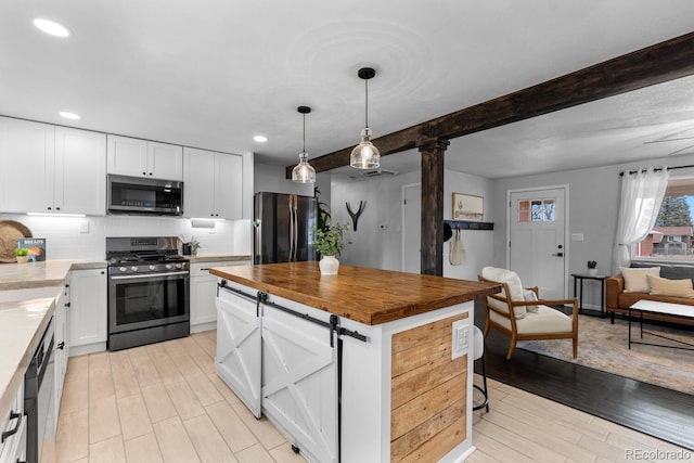 kitchen featuring beam ceiling, stainless steel appliances, decorative backsplash, white cabinets, and wood counters