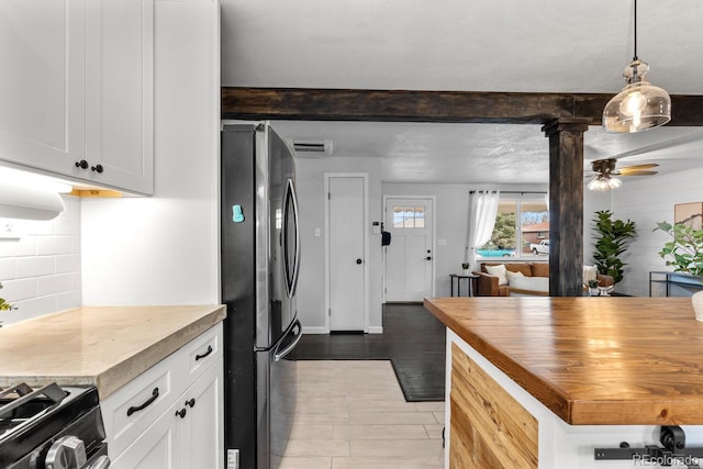 kitchen featuring tasteful backsplash, wooden counters, freestanding refrigerator, white cabinetry, and ceiling fan