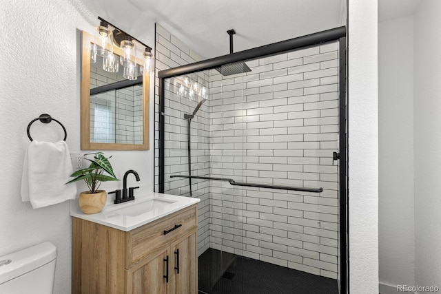 full bath featuring a stall shower, vanity, and toilet