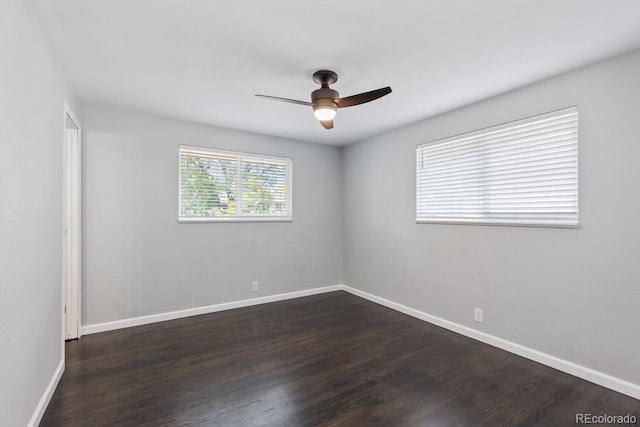 spare room featuring dark wood-style floors, baseboards, and a ceiling fan