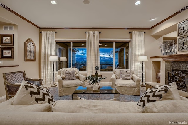 living area with a fireplace, visible vents, crown molding, and recessed lighting