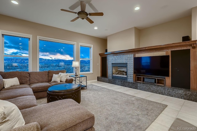 tiled living area with a ceiling fan, recessed lighting, baseboards, and a tile fireplace