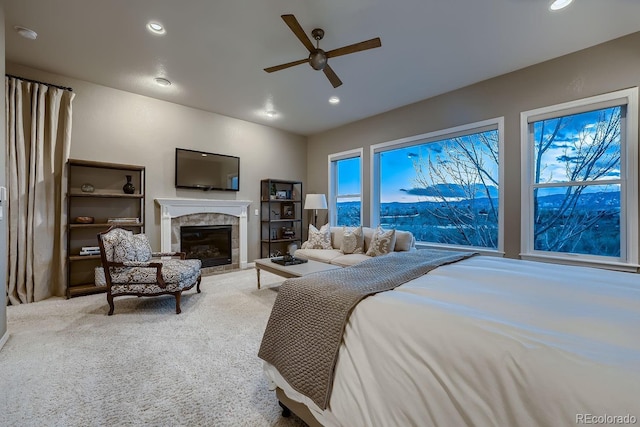 bedroom with recessed lighting, carpet flooring, ceiling fan, and a tiled fireplace