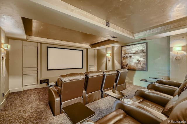 carpeted home theater with baseboards, visible vents, and a raised ceiling