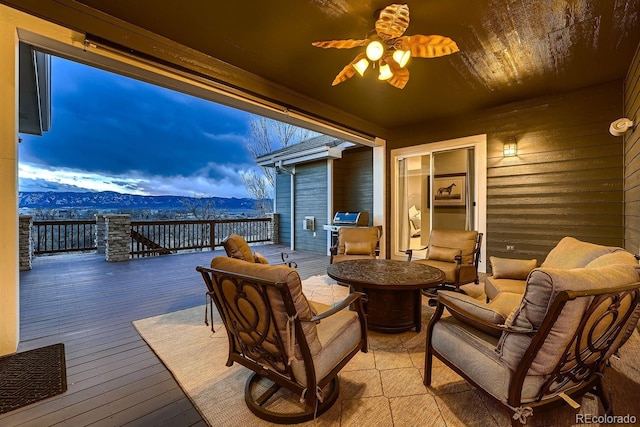 view of patio featuring a deck with mountain view, a grill, an outdoor living space, and a ceiling fan