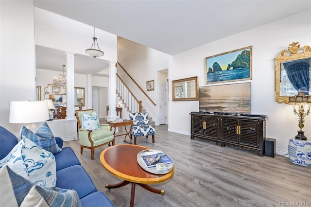 living room with decorative columns and light hardwood / wood-style flooring