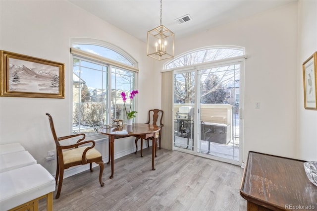 interior space featuring light wood-type flooring and an inviting chandelier