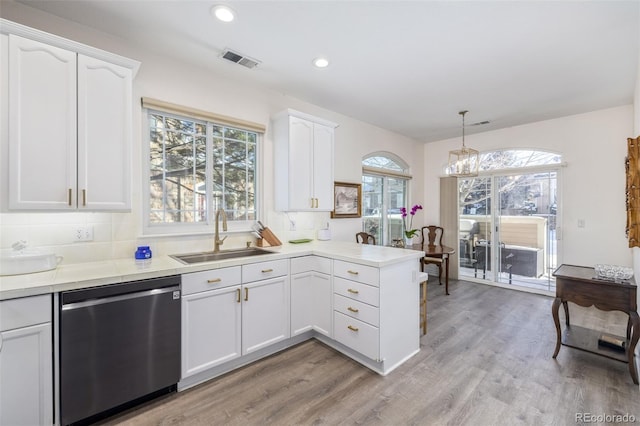 kitchen with sink, stainless steel dishwasher, decorative light fixtures, and white cabinets