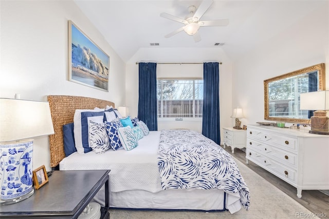 bedroom featuring ceiling fan, wood-type flooring, vaulted ceiling, and multiple windows