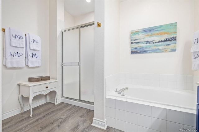 bathroom with independent shower and bath and wood-type flooring