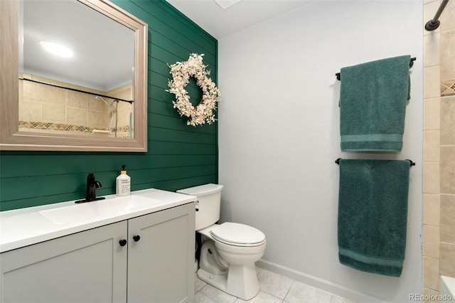 bathroom with vanity, toilet, tile patterned flooring, and a tile shower