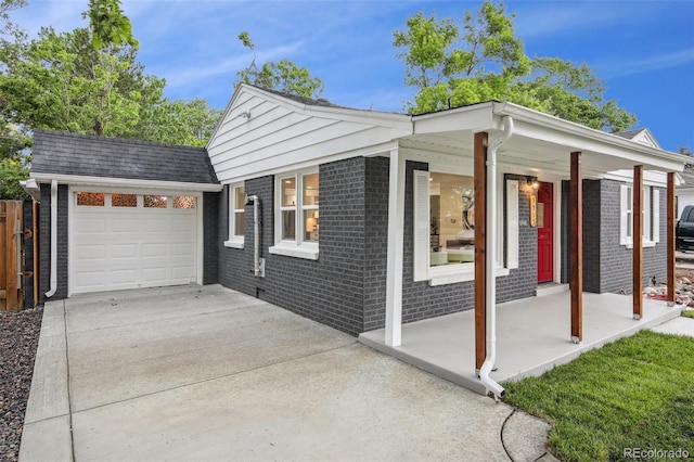 5515 Dudley Ct, Arvada, CO 80002 - view of side of home featuring brick siding, driveway, covered porch, and a garage