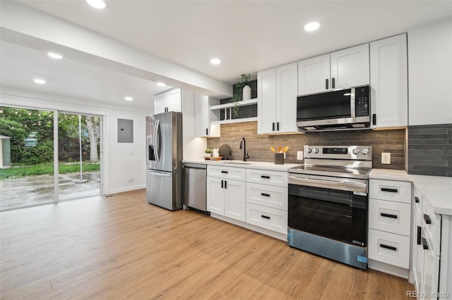 5515 Dudley Ct, Arvada, CO 80002 - kitchen featuring stainless steel appliances, light wood-style flooring, light countertops, electric panel, and recessed lighting
