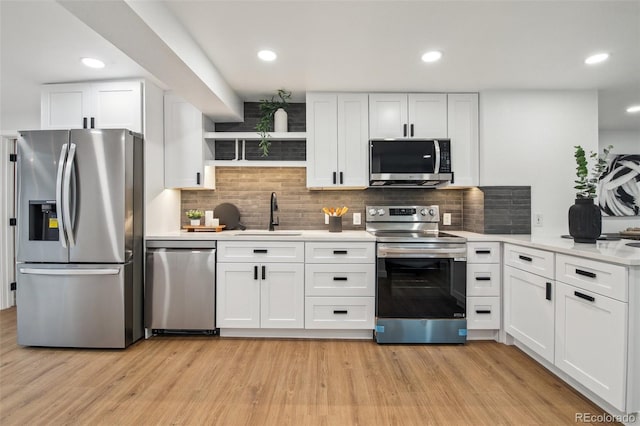 5515 Dudley Ct, Arvada, CO 80002 - kitchen featuring appliances with stainless steel finishes, white cabinetry, light countertops, tasteful backsplash, and recessed lighting