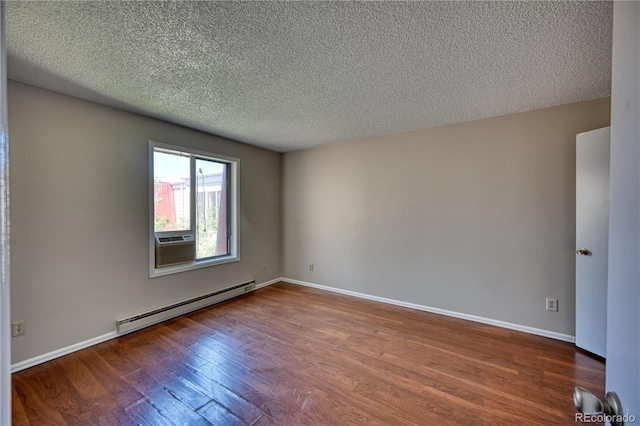 spare room with a baseboard radiator, wood finished floors, a textured ceiling, and baseboards