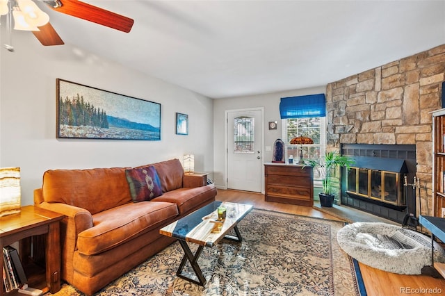 living room featuring a fireplace, hardwood / wood-style floors, and ceiling fan