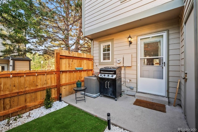 view of exterior entry featuring cooling unit and a patio