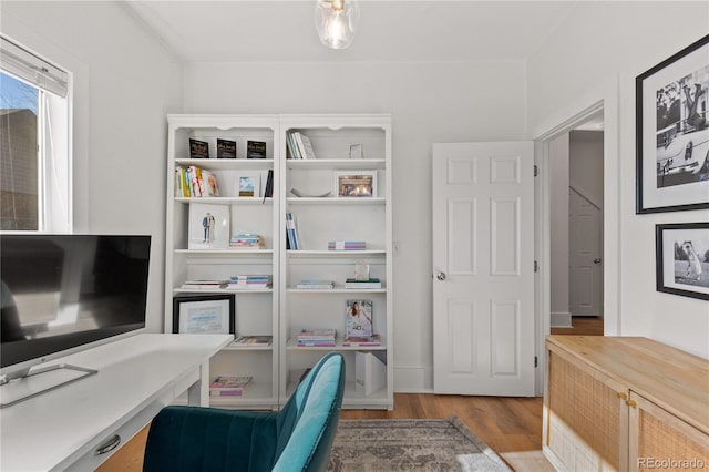 home office with light hardwood / wood-style flooring