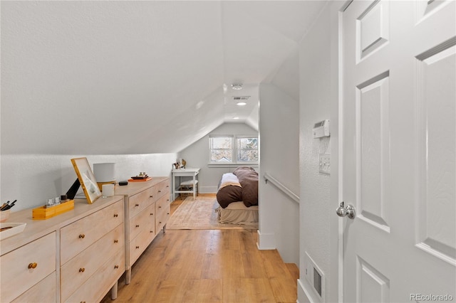 bedroom featuring vaulted ceiling and light hardwood / wood-style floors