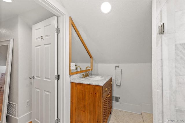 bathroom featuring lofted ceiling, vanity, and tile patterned flooring