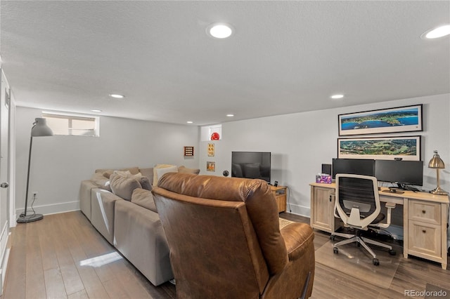 living room featuring light hardwood / wood-style flooring and a textured ceiling