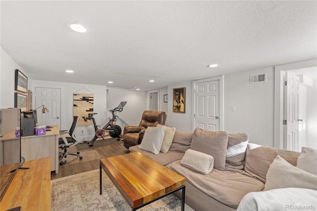 living room with a textured ceiling and light wood-type flooring