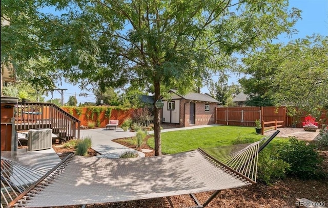 view of yard with a wooden deck, a patio, and a storage shed