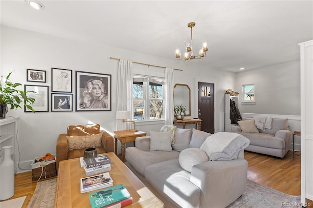 living room featuring a chandelier and light wood-type flooring