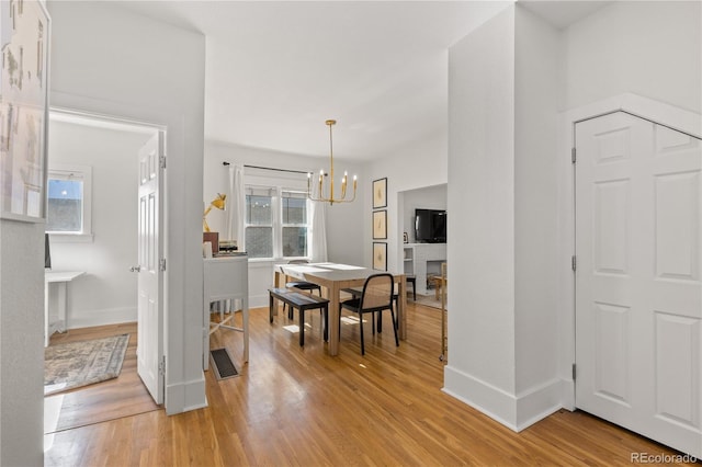 dining area featuring an inviting chandelier, plenty of natural light, and light hardwood / wood-style floors