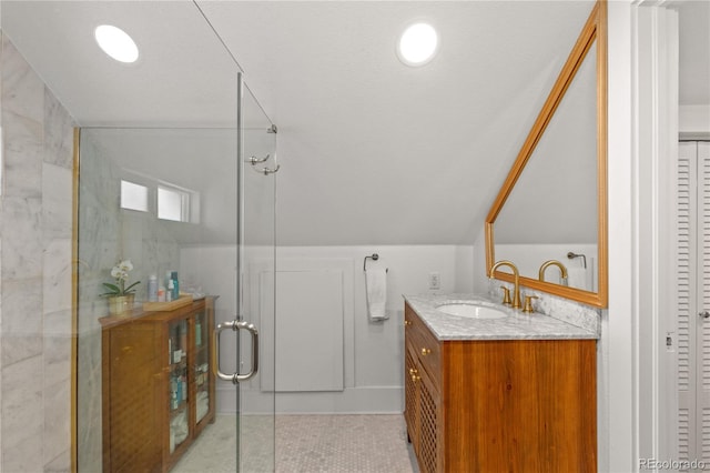 bathroom featuring vaulted ceiling, vanity, and walk in shower