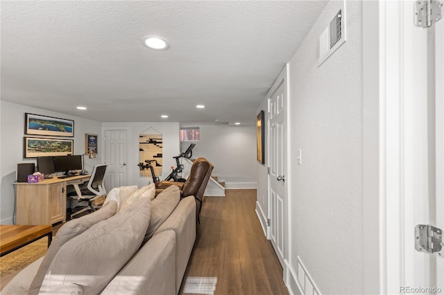 living room with dark hardwood / wood-style floors and a textured ceiling