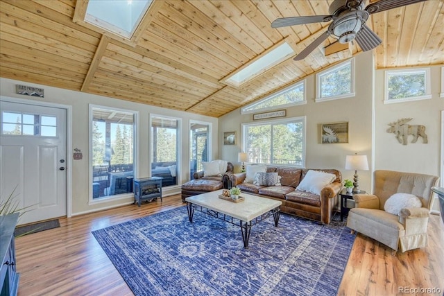 living area featuring a skylight, a ceiling fan, wood ceiling, wood finished floors, and high vaulted ceiling