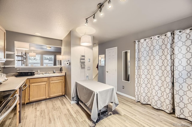 kitchen featuring stainless steel appliances, light hardwood / wood-style floors, and a textured ceiling