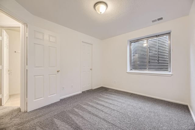 unfurnished bedroom featuring carpet, a textured ceiling, and a closet