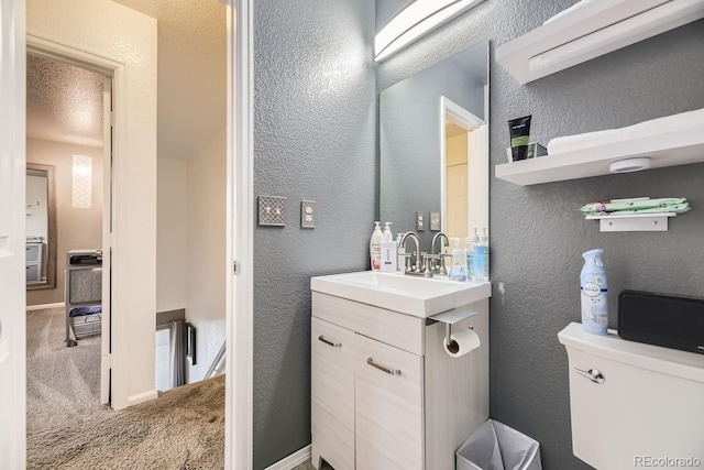 bathroom featuring vanity, toilet, and a textured ceiling