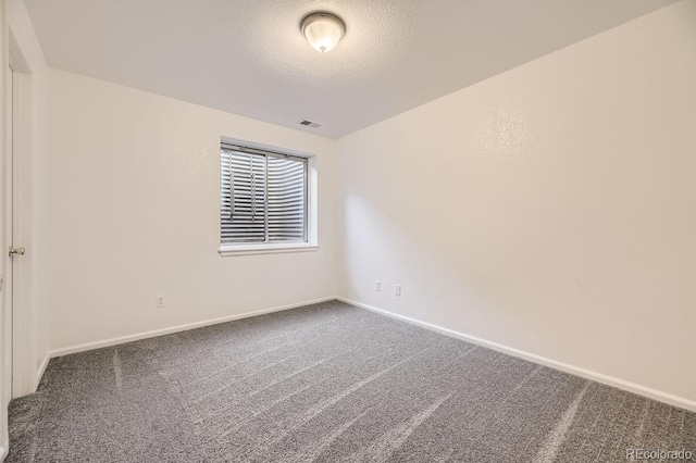 carpeted spare room with a textured ceiling