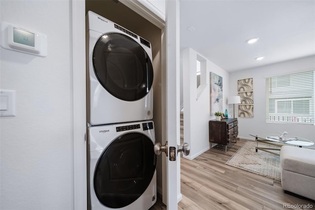 washroom featuring stacked washer / dryer and light hardwood / wood-style flooring