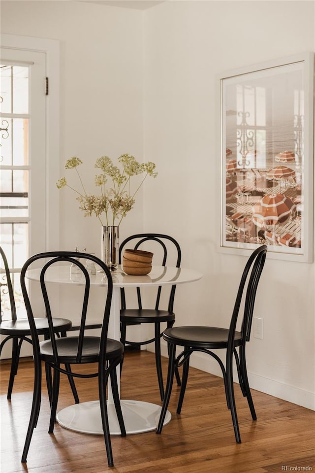 dining space featuring baseboards and wood finished floors